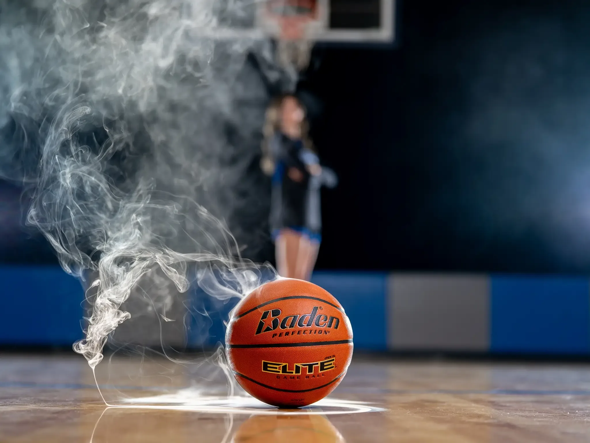 A basketball on the court wrapped in smoke, a player behind it